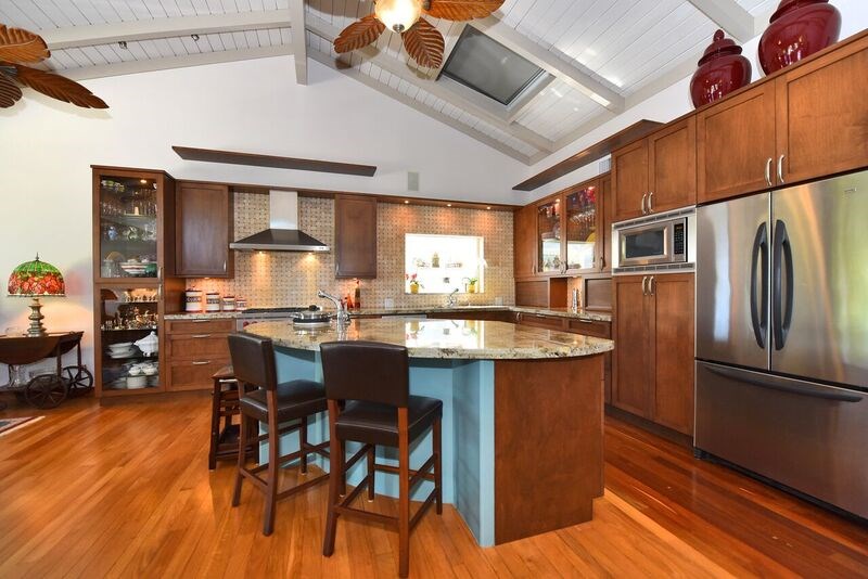 5045 Lower Honoapiilani Road, Unit HOUSE #5 Lahaina, HI 96761 - Photo 3 of 30 a kitchen with stainless steel appliances granite countertop a refrigerator a sink dishwasher a dining table and chairs with wooden floor