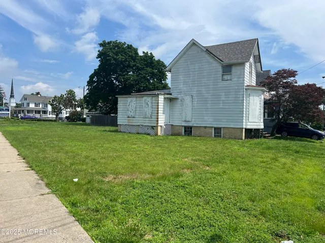 a view of a big house with a big yard and large trees