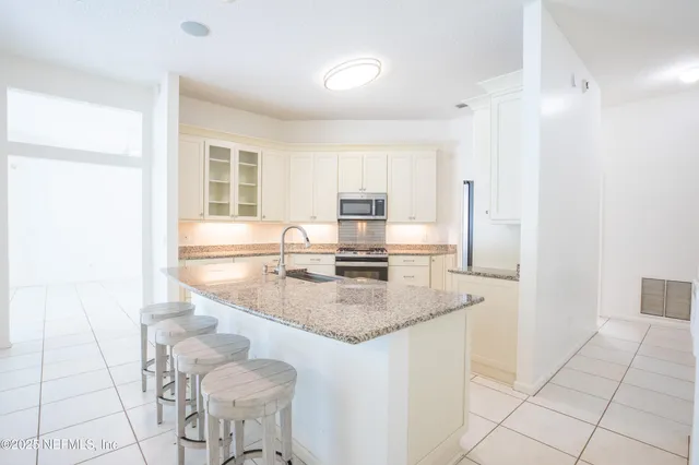 a kitchen with stainless steel appliances granite countertop a sink stove and cabinets