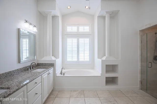 a spacious bathroom with a granite countertop tub sink and mirror