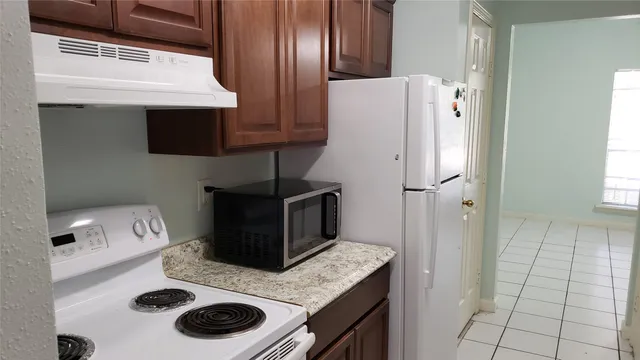 a kitchen with a refrigerator and a stove