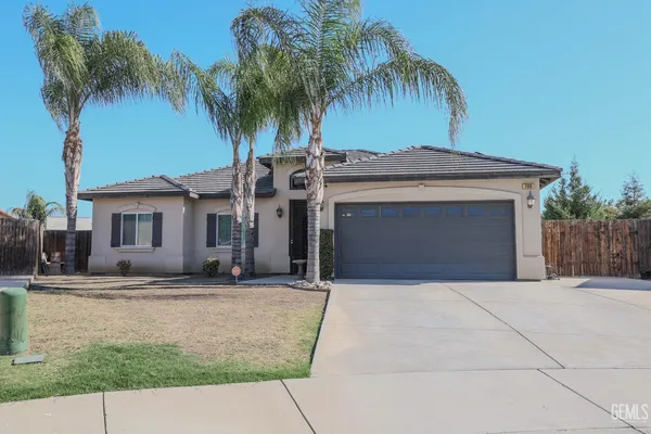 a front view of a house with a yard and palm trees