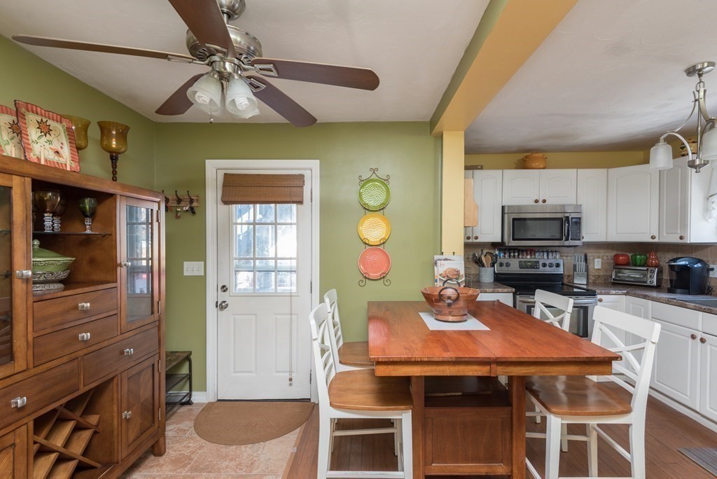 14 Sumner Street Taunton, MA 02780 - Photo 3 of 22 a kitchen with stainless steel appliances kitchen island granite countertop a table chairs in it and wooden floors