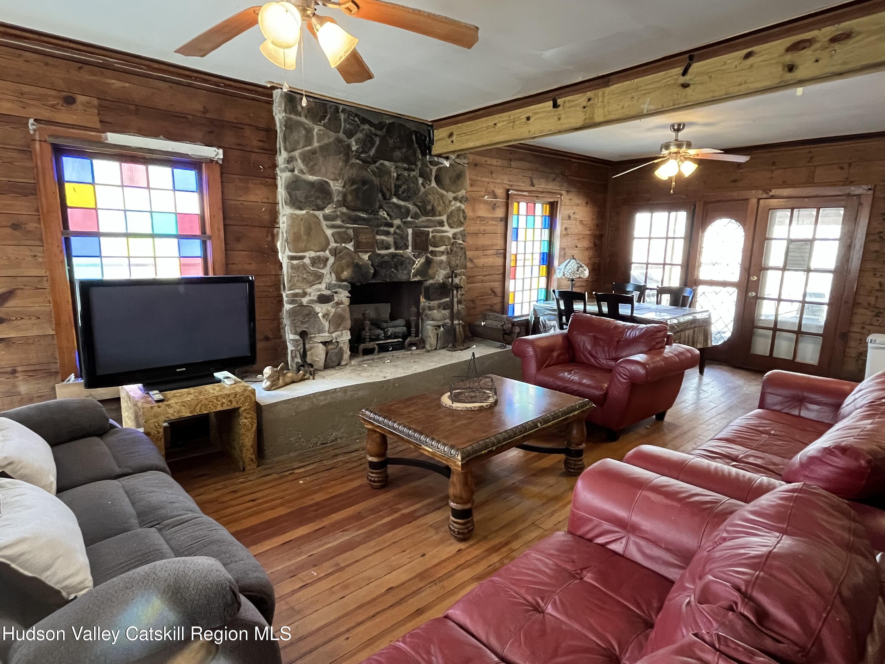 311 North Lake Road Haines Falls, NY 12436 - Photo 2 of 34 a living room with furniture a fireplace and a chandelier