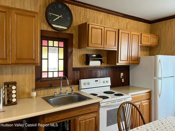 a kitchen with stainless steel appliances a dining table chairs and granite counter tops