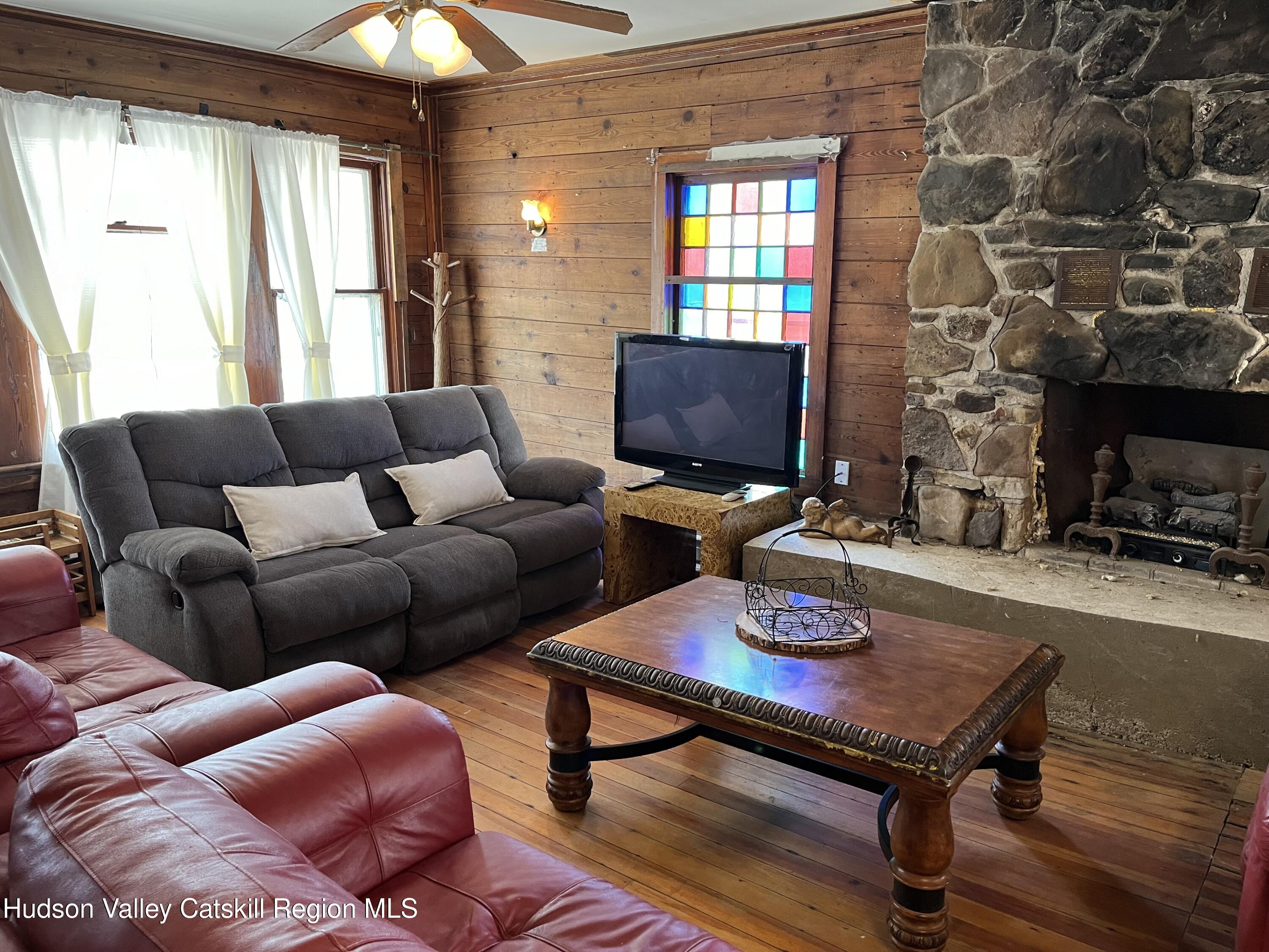 311 North Lake Road Haines Falls, NY 12436 - Photo 7 of 34 a living room with furniture a flat screen tv and a fireplace