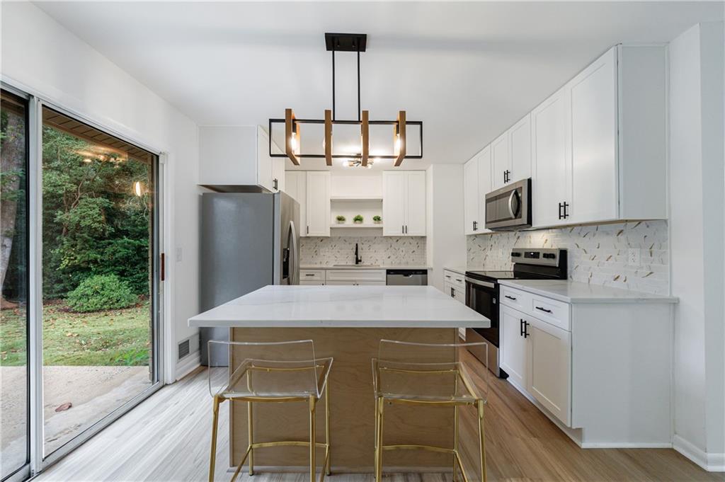 4360 Sasanqua Court Tucker, GA 30084 - Photo 11 of 37 a kitchen with stainless steel appliances a stove refrigerator sink and cabinets
