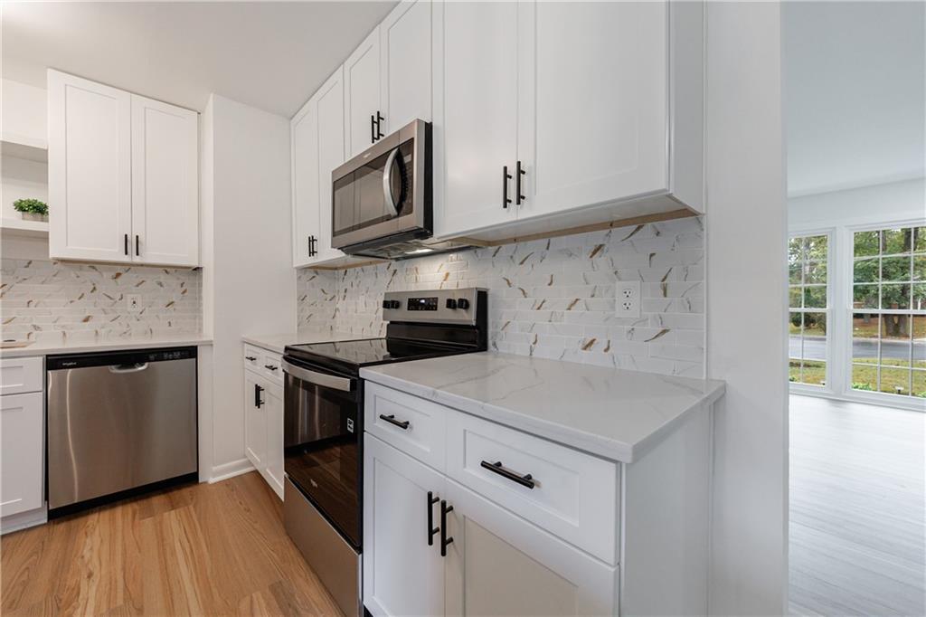 4360 Sasanqua Court Tucker, GA 30084 - Photo 13 of 37 a kitchen with stainless steel appliances white cabinets and a granite counter tops