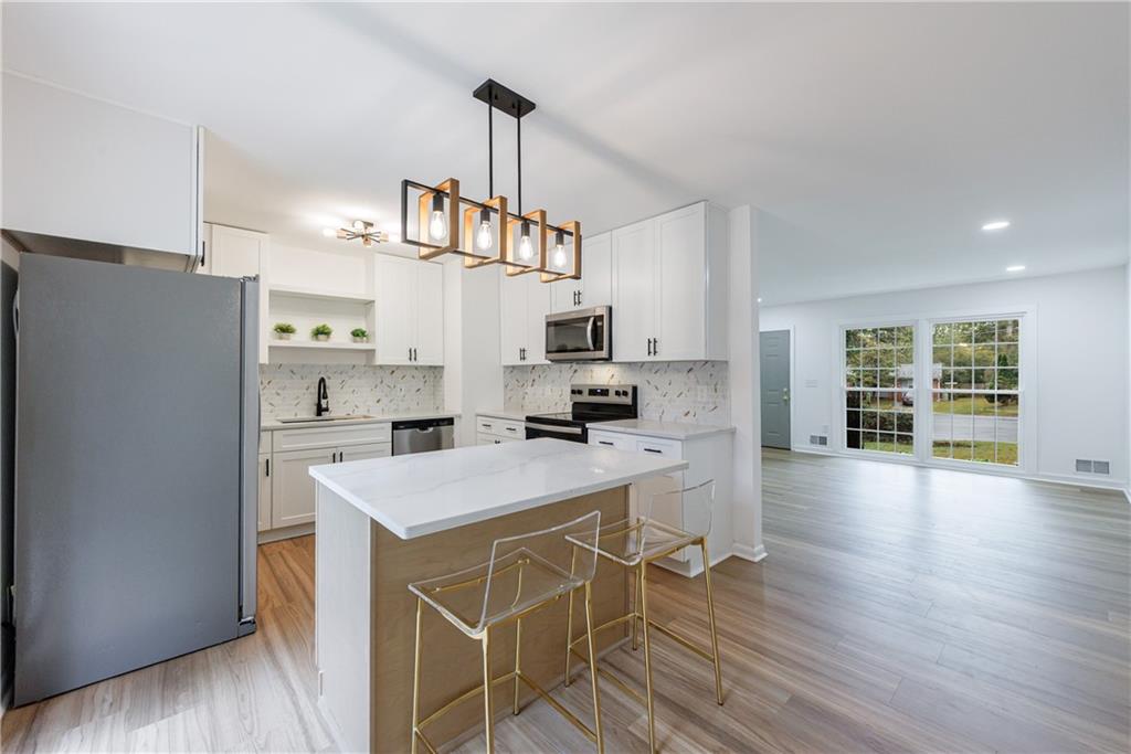 4360 Sasanqua Court Tucker, GA 30084 - Photo 10 of 37 a kitchen with a refrigerator a stove cabinets and wooden floor