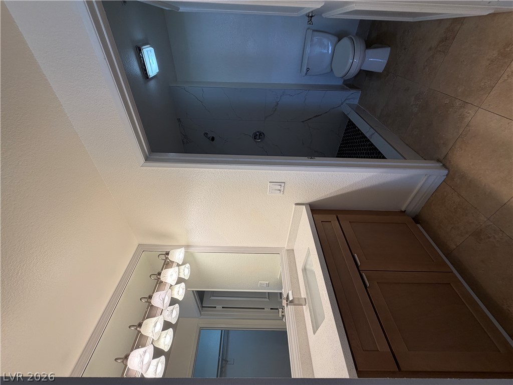 210 East Flamingo Road, Unit 126 Las Vegas, NV 89169 - Photo 9 of 16 A well-appointed bathroom features a single vanity, a sleek toilet, and a walk-in shower with stylish tilework.