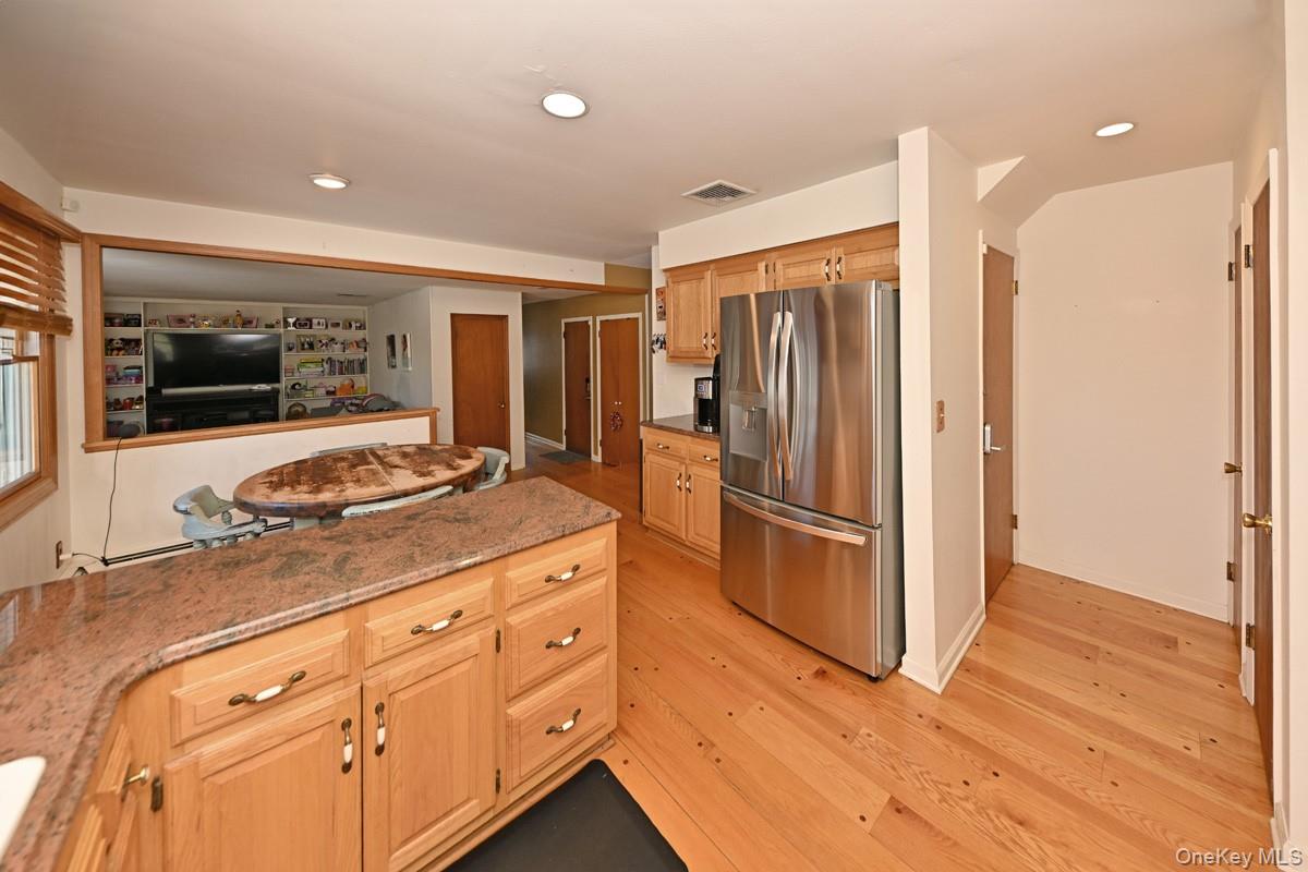 7 Lexington Road New City, NY 10956 - Photo 36 of 36 Kitchen featuring stainless steel refrigerator with ice dispenser, light stone counters, recessed lighting, light wood finished floors, and open floor plan