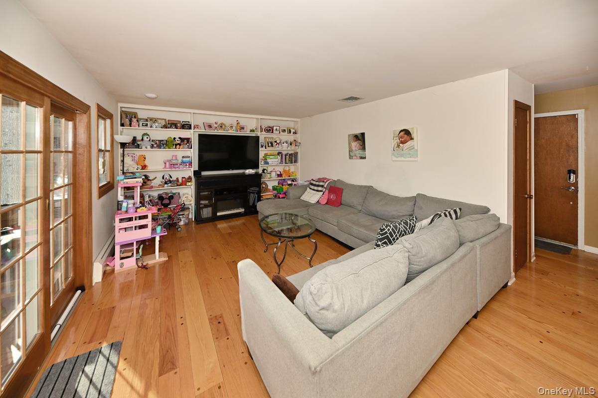7 Lexington Road New City, NY 10956 - Photo 19 of 36 Living area with light wood finished floors, a glass covered fireplace, and built in features