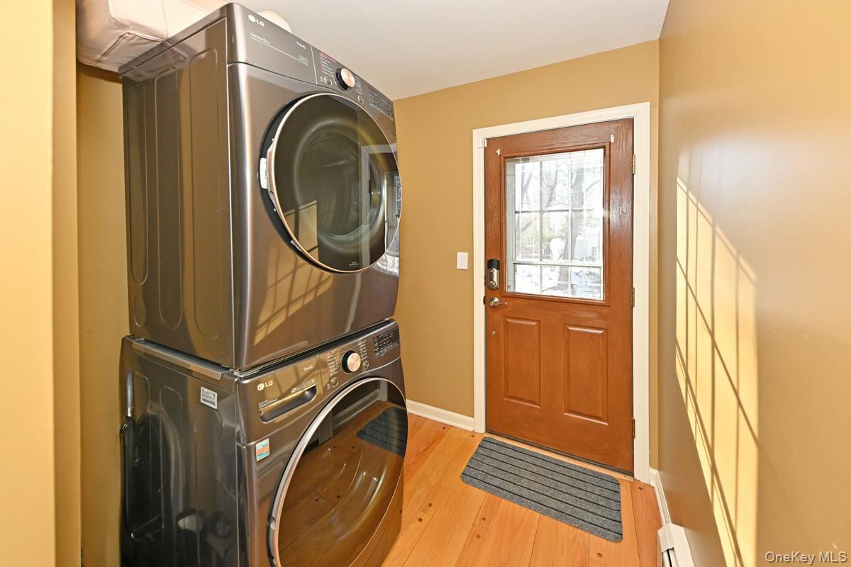 7 Lexington Road New City, NY 10956 - Photo 24 of 36 Washroom featuring stacked washer / drying machine, light wood-style floors, and baseboard heating