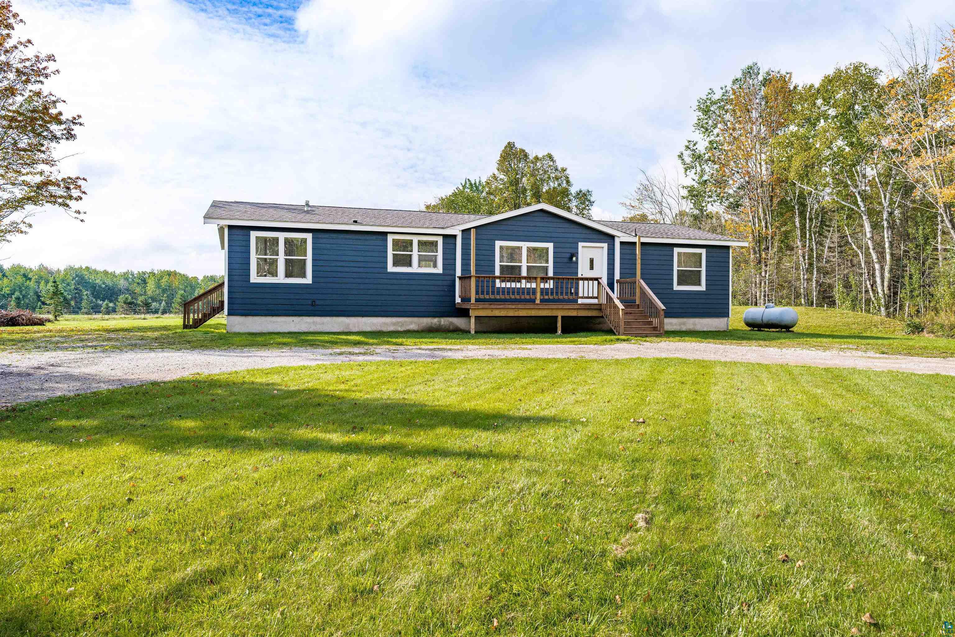 3126 Beyer Road Duluth, MN 55804 - Photo 4 of 23 Single-story residence featuring blue siding, white trim windows, and a dark shingle roof