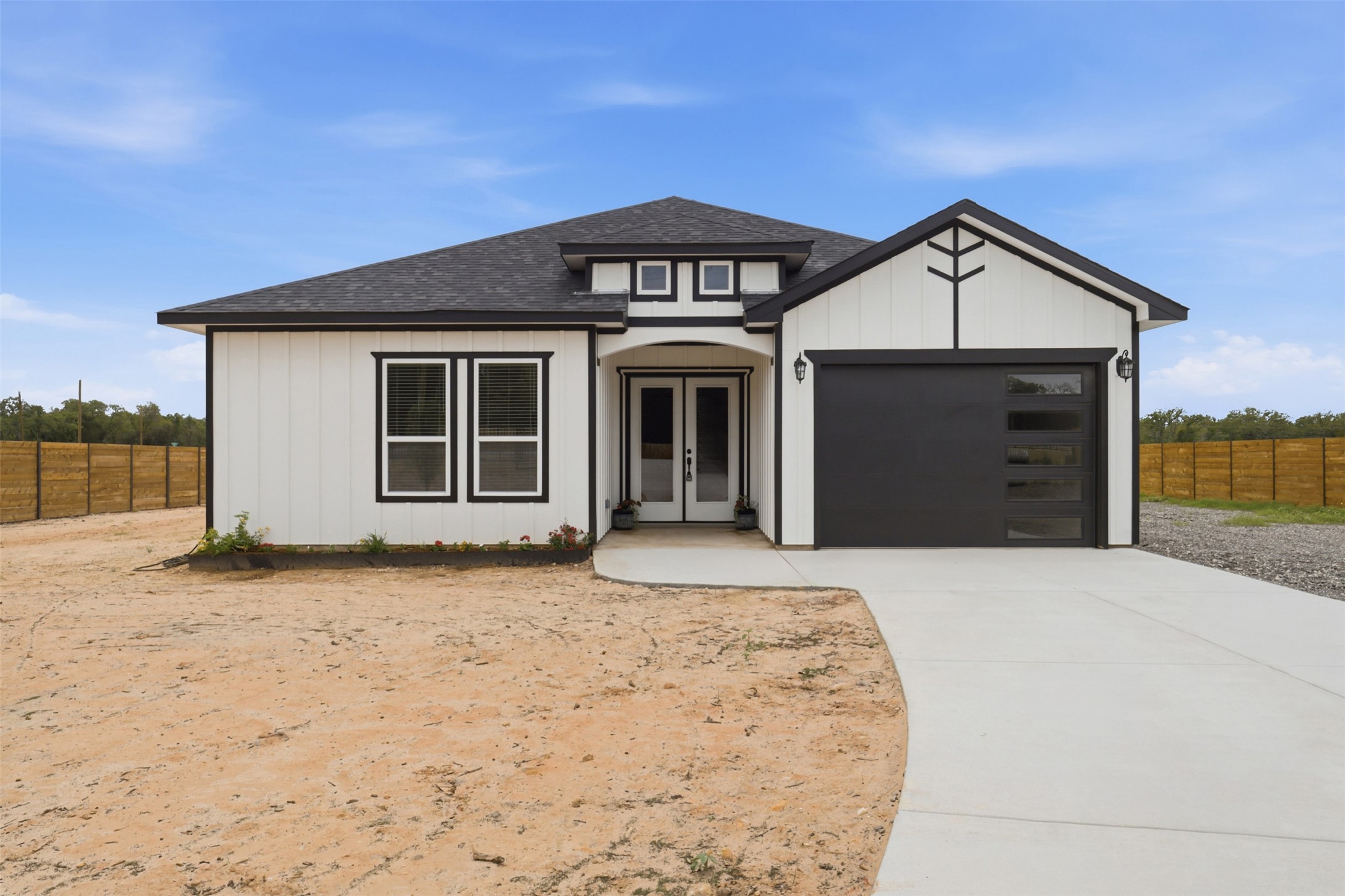 123 Los Robles Road Elgin, TX 78621 - Photo 1 of 21 Contemporary single-story residence with a black shingled roof and white vertical siding