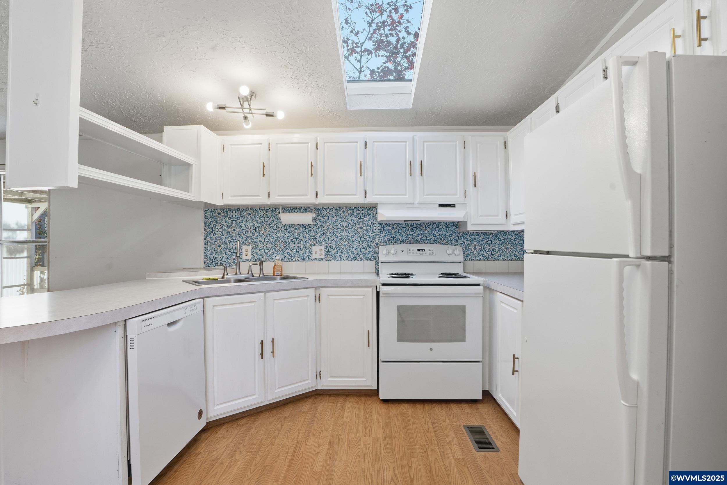 277 Edwards Road, Unit 145 Monmouth, OR 97361 - Photo 7 of 47 a kitchen with granite countertop white cabinets and white appliances