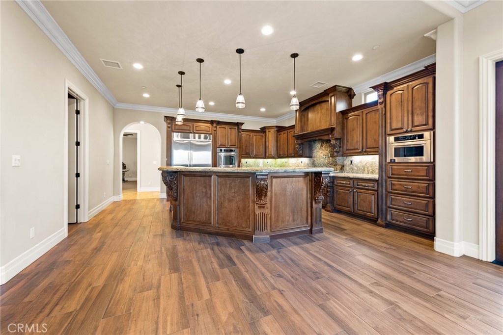 670 Pinnacle Ridge Road Riverside, CA 92506 - Photo 23 of 75 a kitchen with stainless steel appliances kitchen island wooden cabinets and granite counter tops