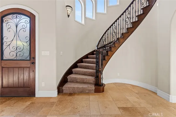 a view of a white house in front of a big yard with large trees