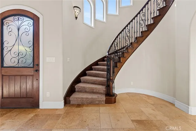 a view of a white house in front of a big yard with large trees