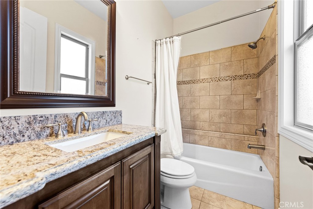 670 Pinnacle Ridge Road Riverside, CA 92506 - Photo 58 of 75 a bathroom with a granite countertop sink a toilet and bathtub