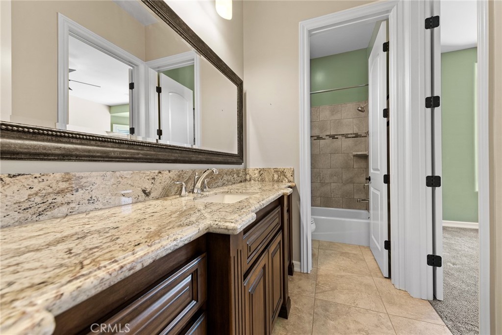 670 Pinnacle Ridge Road Riverside, CA 92506 - Photo 60 of 72 a bathroom with a granite countertop sink and a mirror