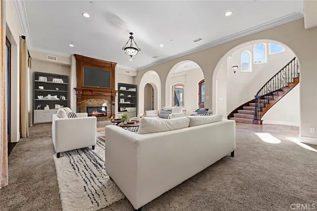 a living room with couches a dining table and a fireplace with wooden floor