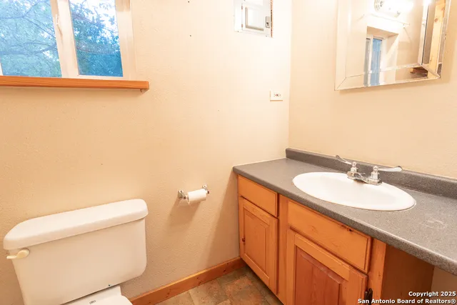a bathroom with a granite countertop toilet and a sink