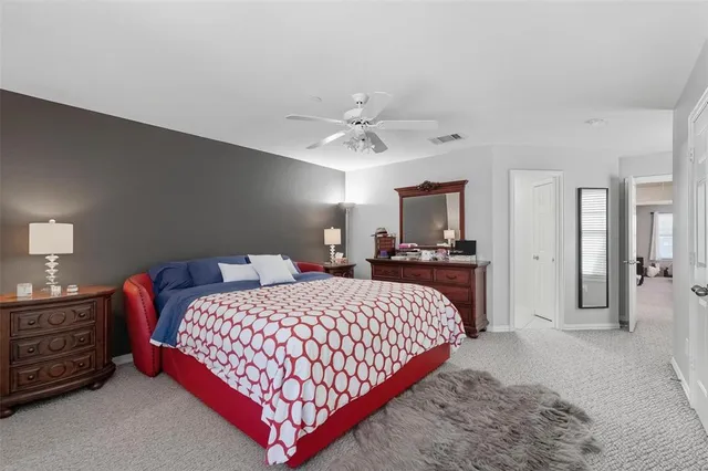 a bedroom with a large bed and a chandelier