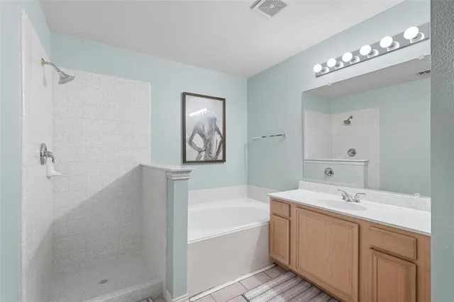 a bathroom with a tub a sink and mirror