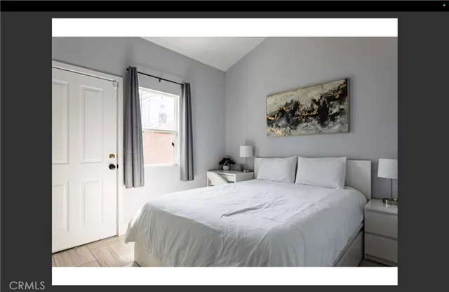 a bedroom with a bed and a painting on the wall