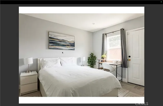 a bedroom with a bed a mirror and a large window