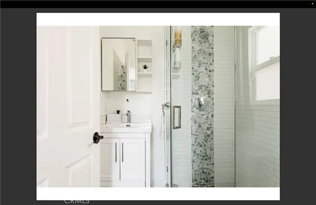 a bathroom with a sink a mirror and shower