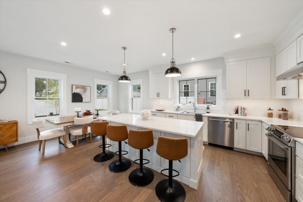 18 Walcott Street Natick, MA 01760 - Photo 11 of 36 a kitchen with stainless steel appliances a dining table chairs stove and sink