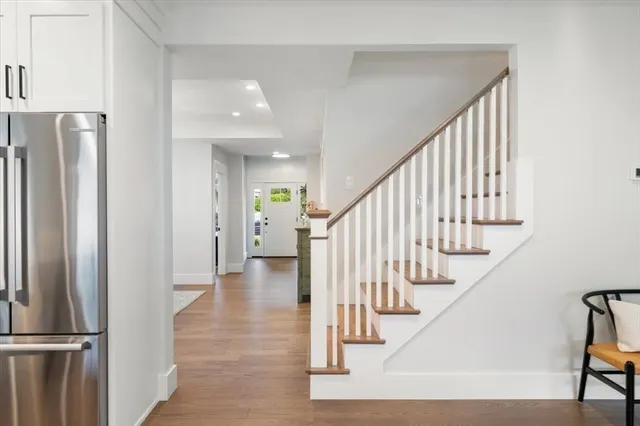 a view of staircase with lots of frames and a refrigerator