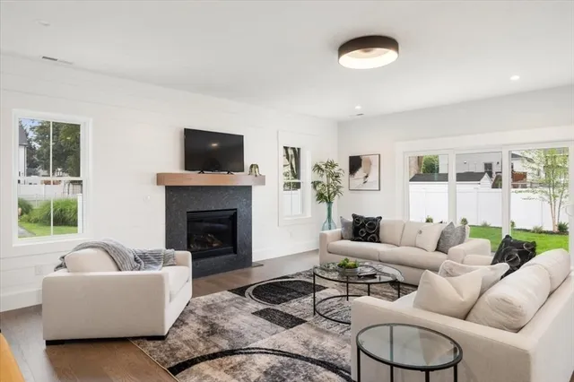 a living room with furniture a flat screen tv and a fireplace