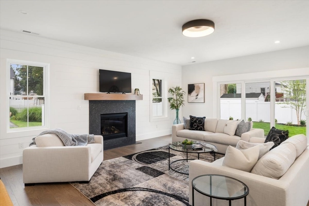 18 Walcott Street Natick, MA 01760 - Photo 14 of 36 a living room with furniture a flat screen tv and a fireplace
