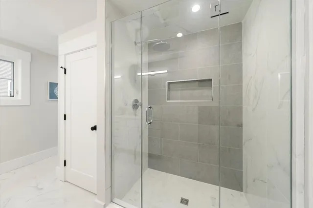 a bathroom with a shower and a glass door