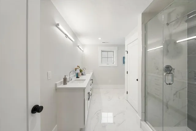 a bathroom with a sink mirror and shower