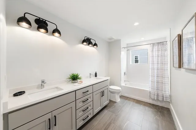 a spacious bathroom with a double vanity sink a mirror and a shower