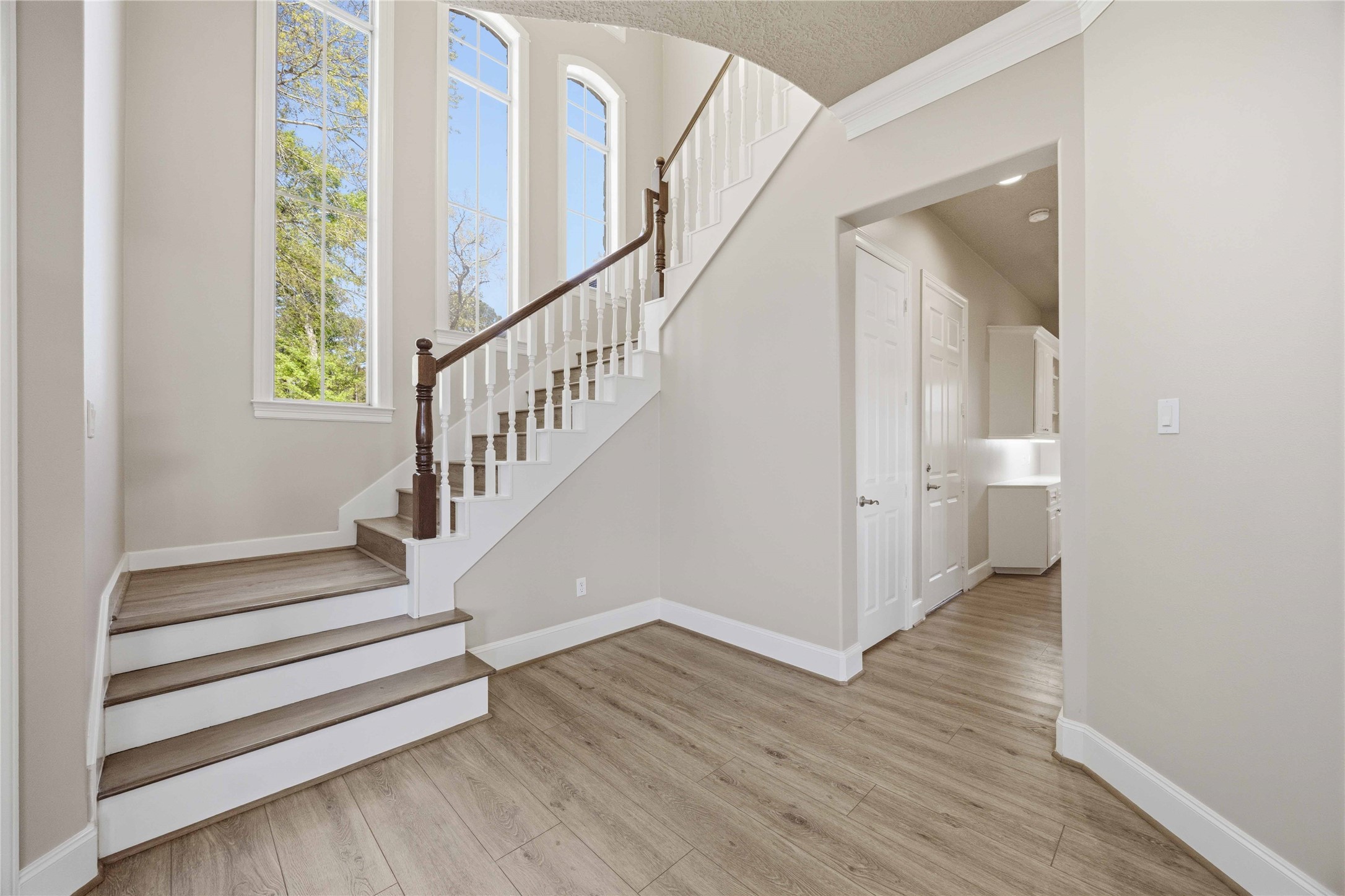 1930 Old River Road Montgomery, TX 77356 - Photo 8 of 49 A lovely wooden staircase boasts a wall of windows with beautiful outdoor views. The opening on the right leads to a butler's kitchen, followed by the utility room.