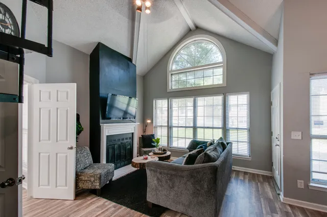 a living room with furniture a fireplace and a large window