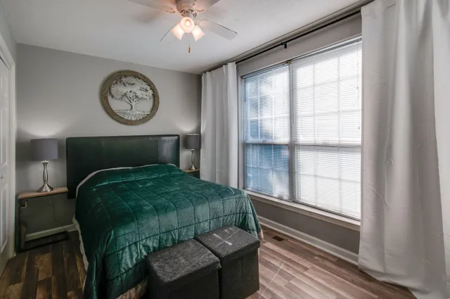 a view of a hallway with wooden floor and livingroom with furniture