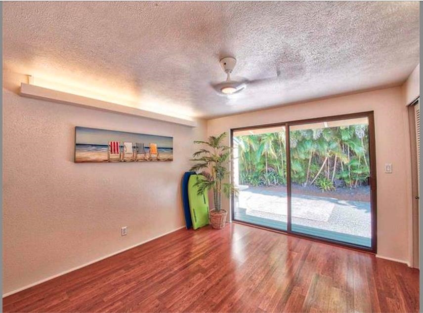 1608 Kauhikoa Road Haiku, HI 96708 - Photo 1 of 1 an empty room with wooden floor and a window