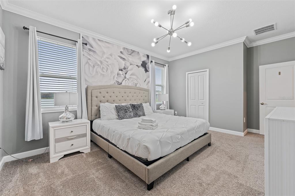 3000 Penelope Loop Kissimmee, FL 34746 - Photo 11 of 53 a bedroom with a large bed and a chandelier