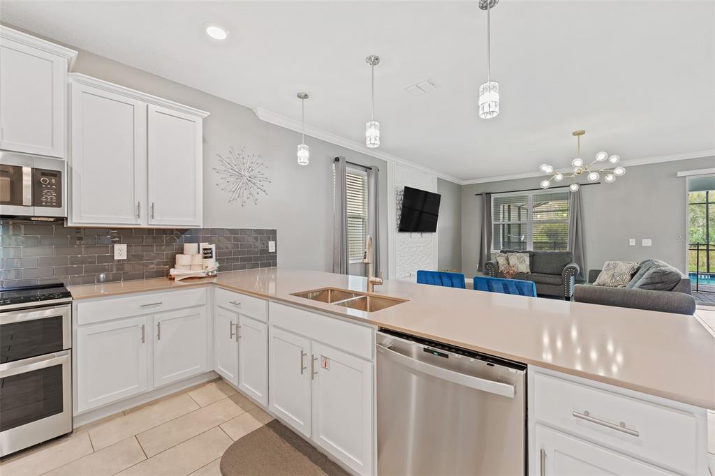3000 Penelope Loop Kissimmee, FL 34746 - Photo 17 of 53 a kitchen with kitchen island a sink appliances and cabinets