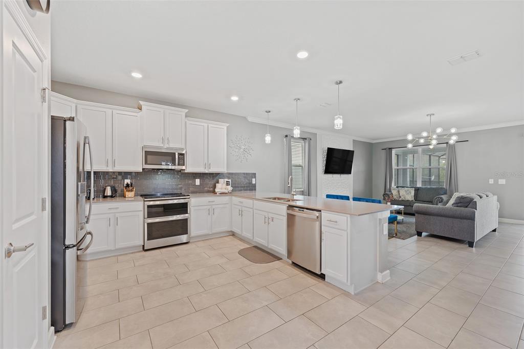 3000 Penelope Loop Kissimmee, FL 34746 - Photo 18 of 53 a kitchen with white cabinets and stainless steel appliances
