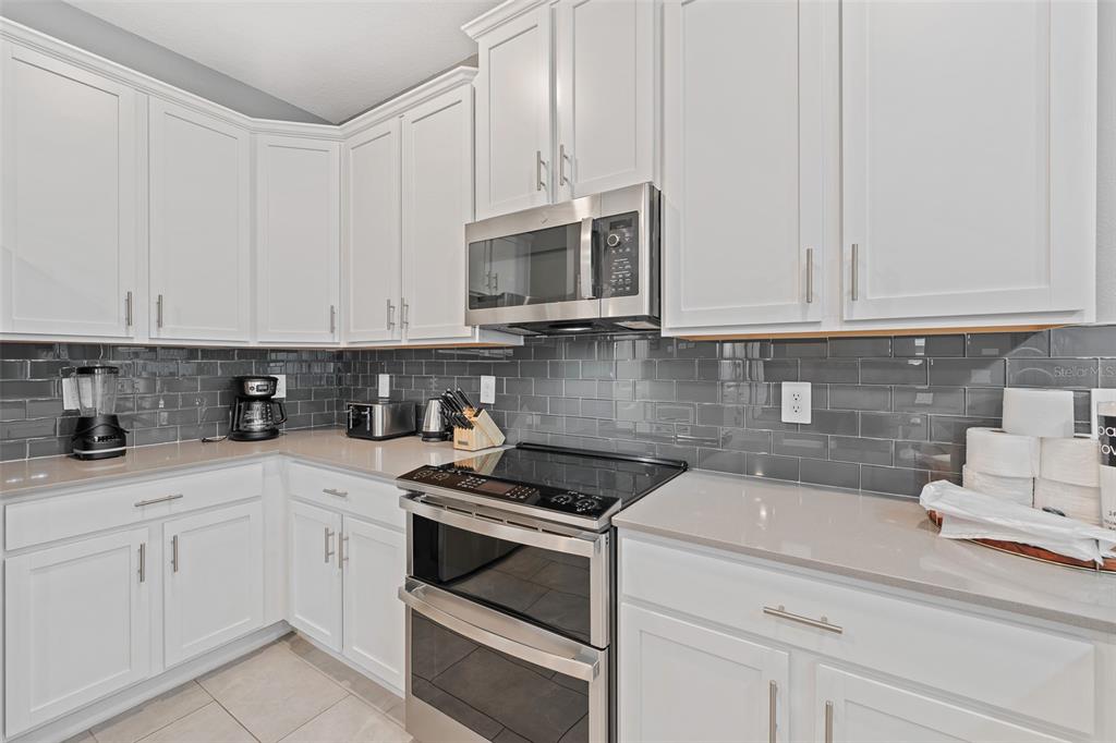 3000 Penelope Loop Kissimmee, FL 34746 - Photo 19 of 53 a kitchen with stainless steel appliances granite countertop white cabinets sink and dishwasher
