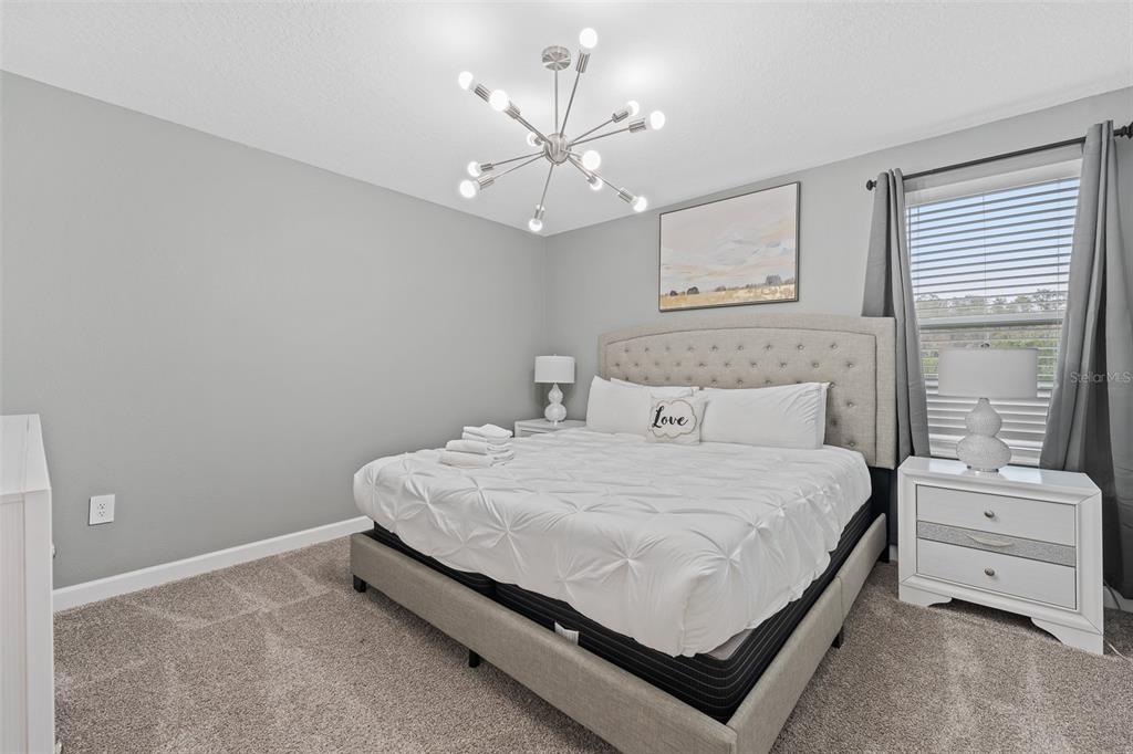3000 Penelope Loop Kissimmee, FL 34746 - Photo 27 of 53 a bedroom with a bed and a chandelier