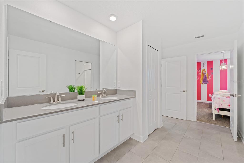 3000 Penelope Loop Kissimmee, FL 34746 - Photo 28 of 53 a en suite bathroom with a granite countertop double sink and a mirror