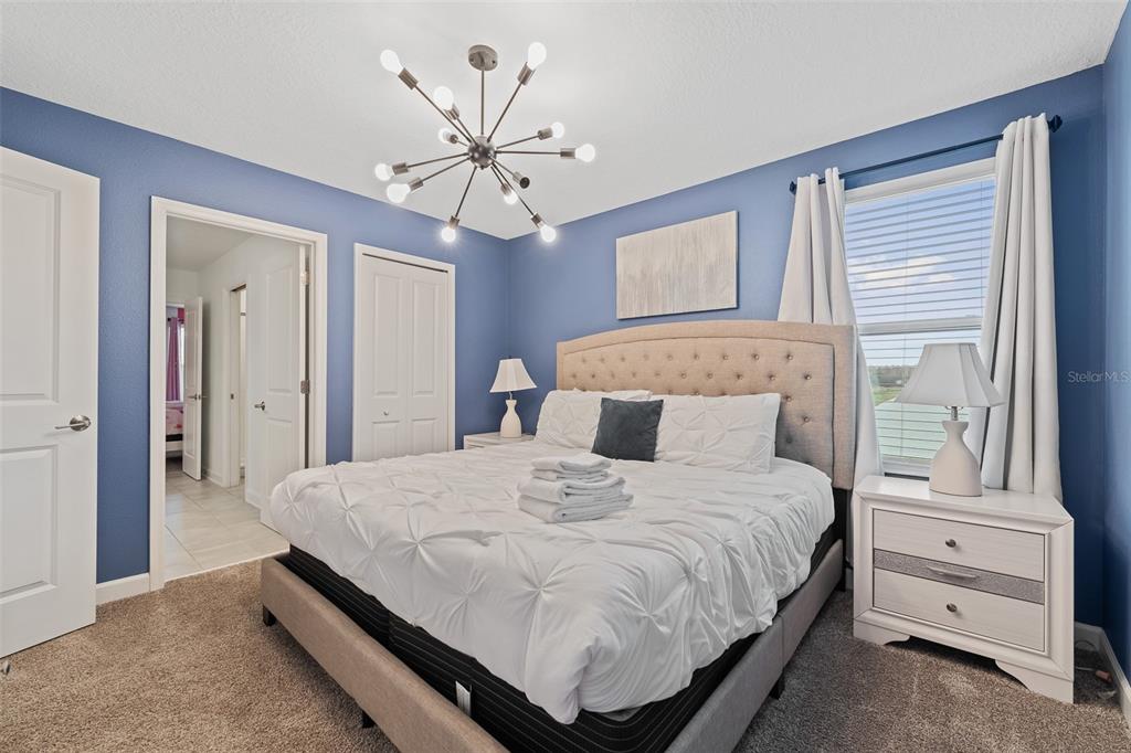 3000 Penelope Loop Kissimmee, FL 34746 - Photo 30 of 53 a bedroom with a bed and a chandelier